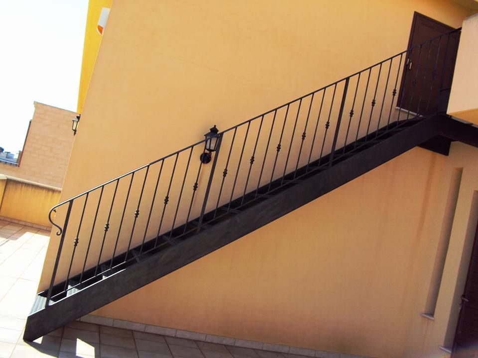 Una serie di scale con una ringhiera in ferro battuto che conduce a una porta