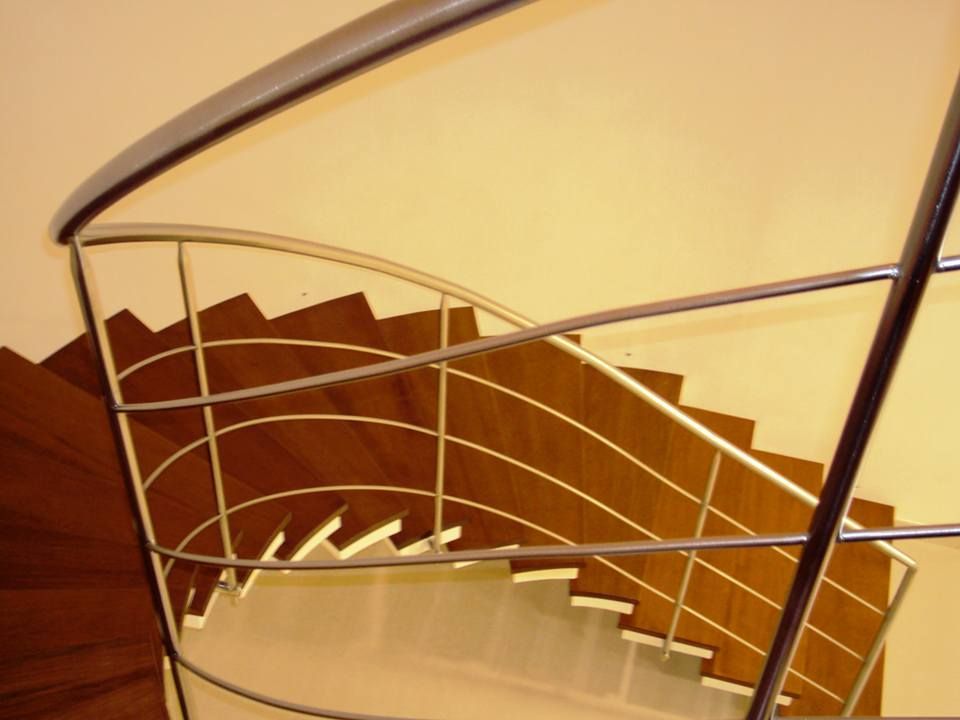 Una scala a chiocciola con ringhiera in metallo e gradini in legno