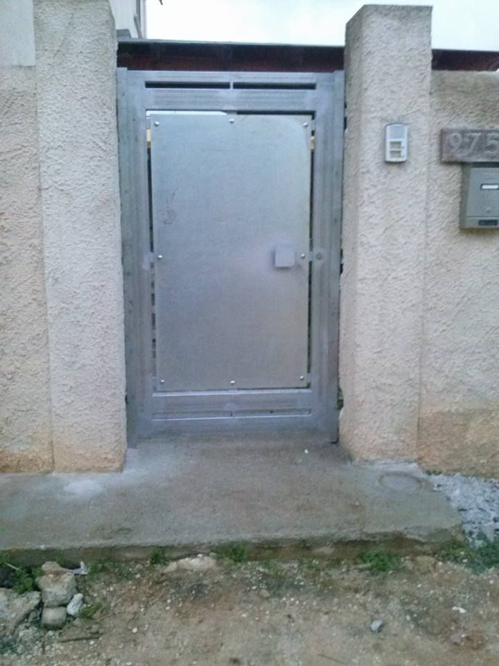 Un cancello in acciaio inossidabile è tra due pilastri di pietra.