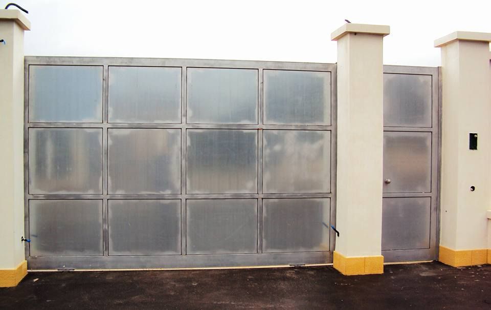 Una recinzione con un cancello scorrevole e due pilastri