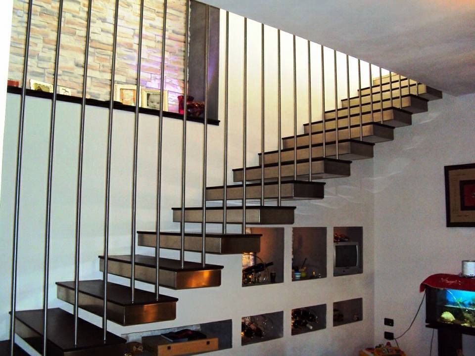 Una scala in un soggiorno con ringhiera in acciaio inossidabile