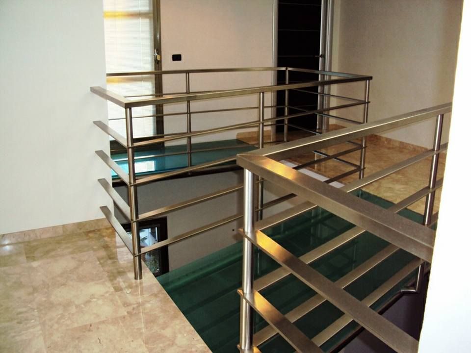 Una scala con ringhiera in acciaio inox e gradini in vetro