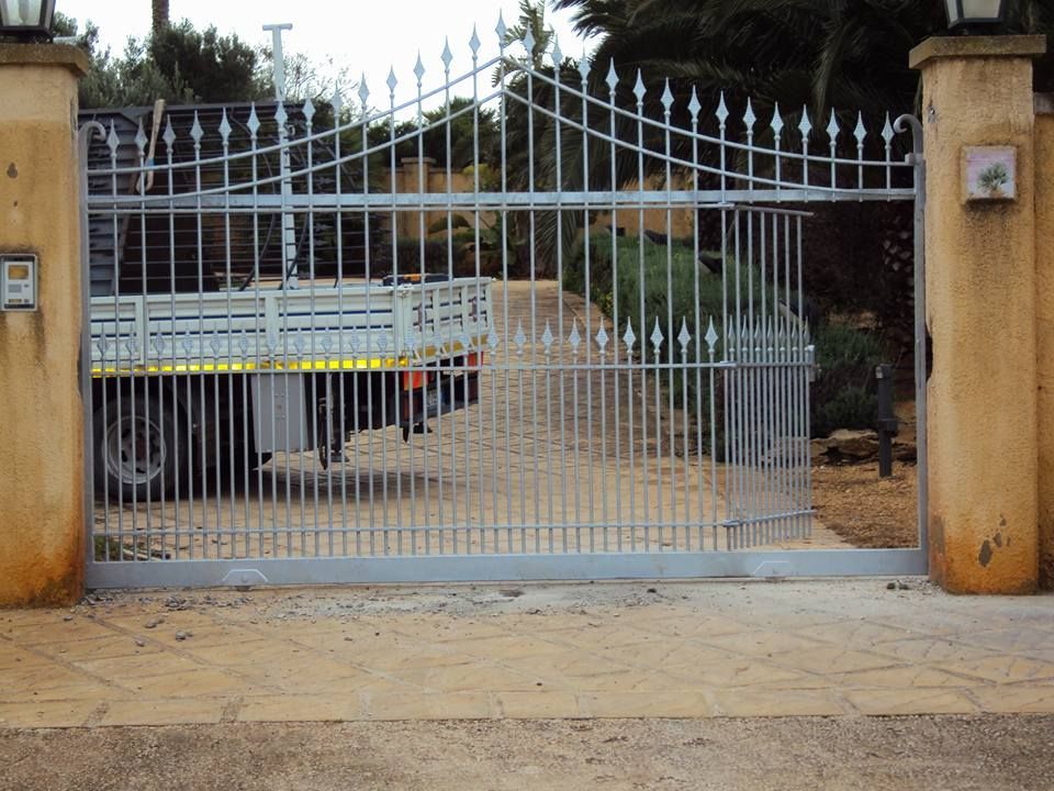 Un camion bianco è parcheggiato dietro un cancello di metallo