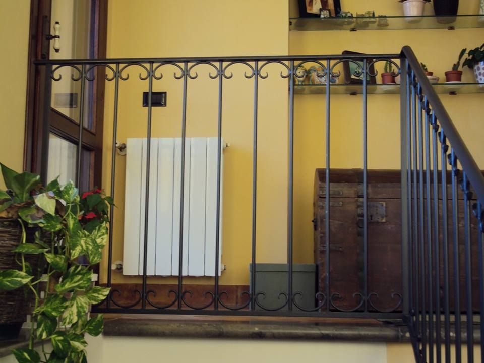 Una scala con ringhiera in ferro battuto e un radiatore
