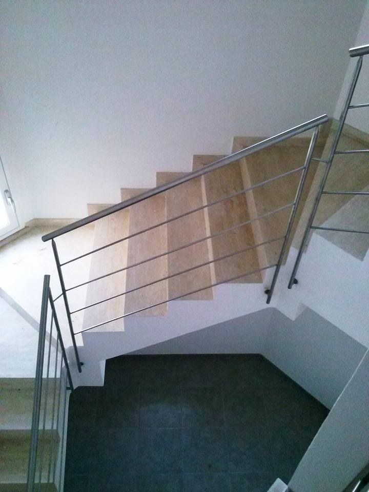 Una scala con ringhiera in metallo e gradini in legno