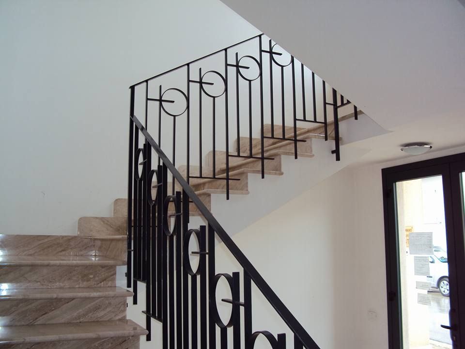 Una scala con una ringhiera in ferro battuto che ha la lettera h su di essa