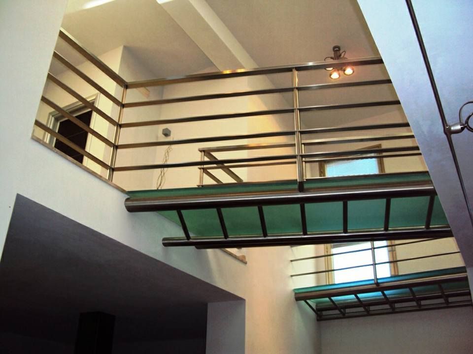 Una scala con pavimento in vetro e ringhiera in metallo