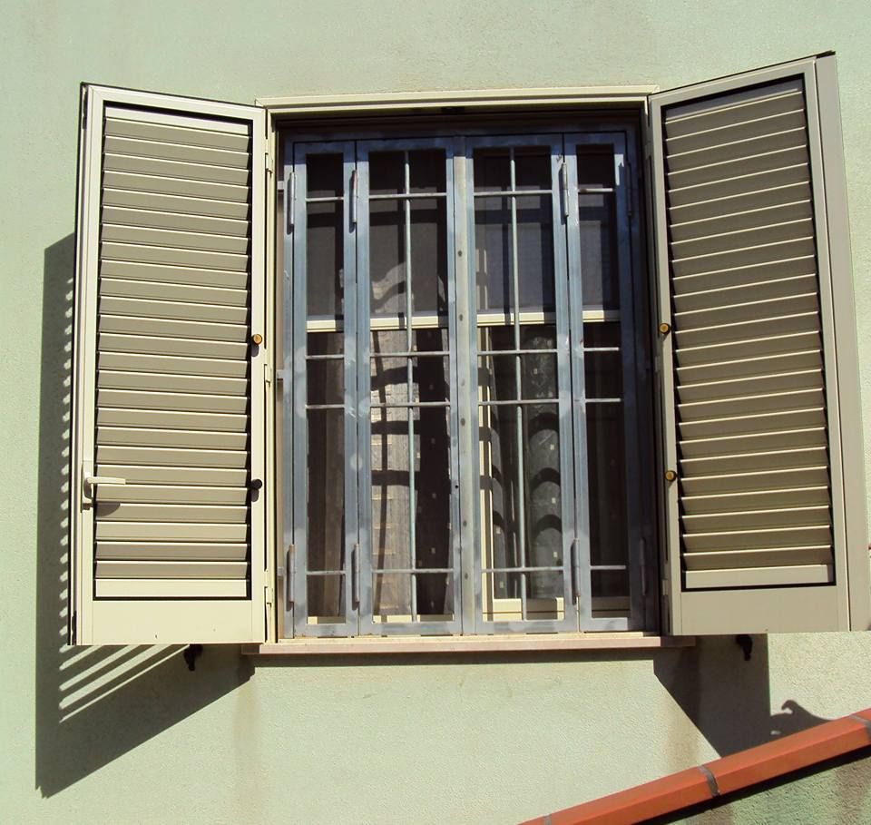Una finestra con persiane e sbarre