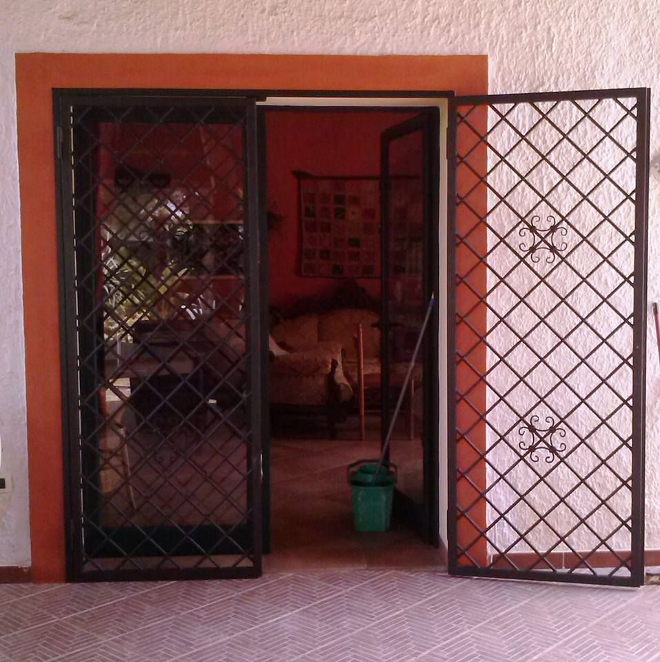 Una porta con un cancello in ferro battuto che si apre su un soggiorno