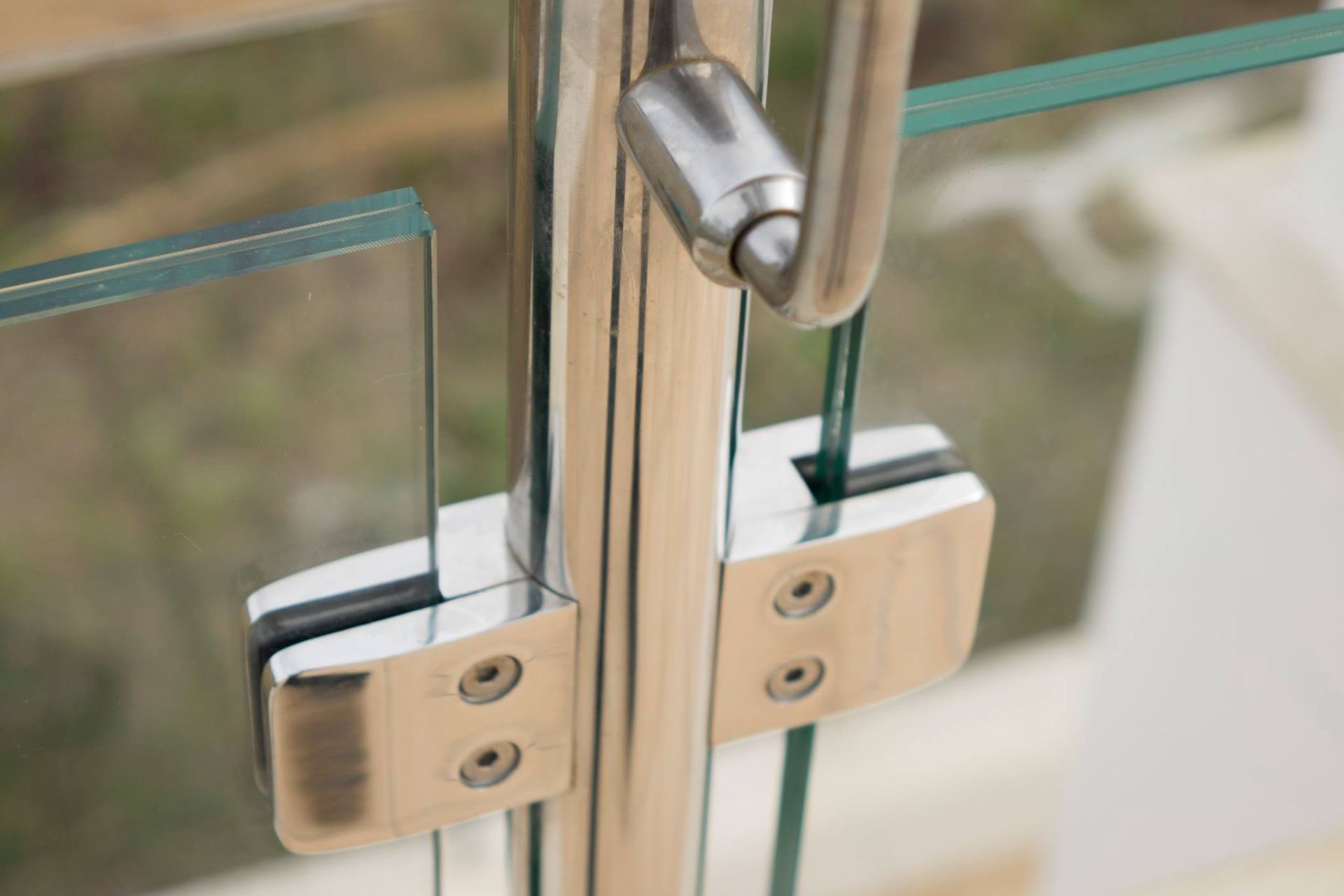 Primo piano di una ringhiera in acciaio inox con vetro.