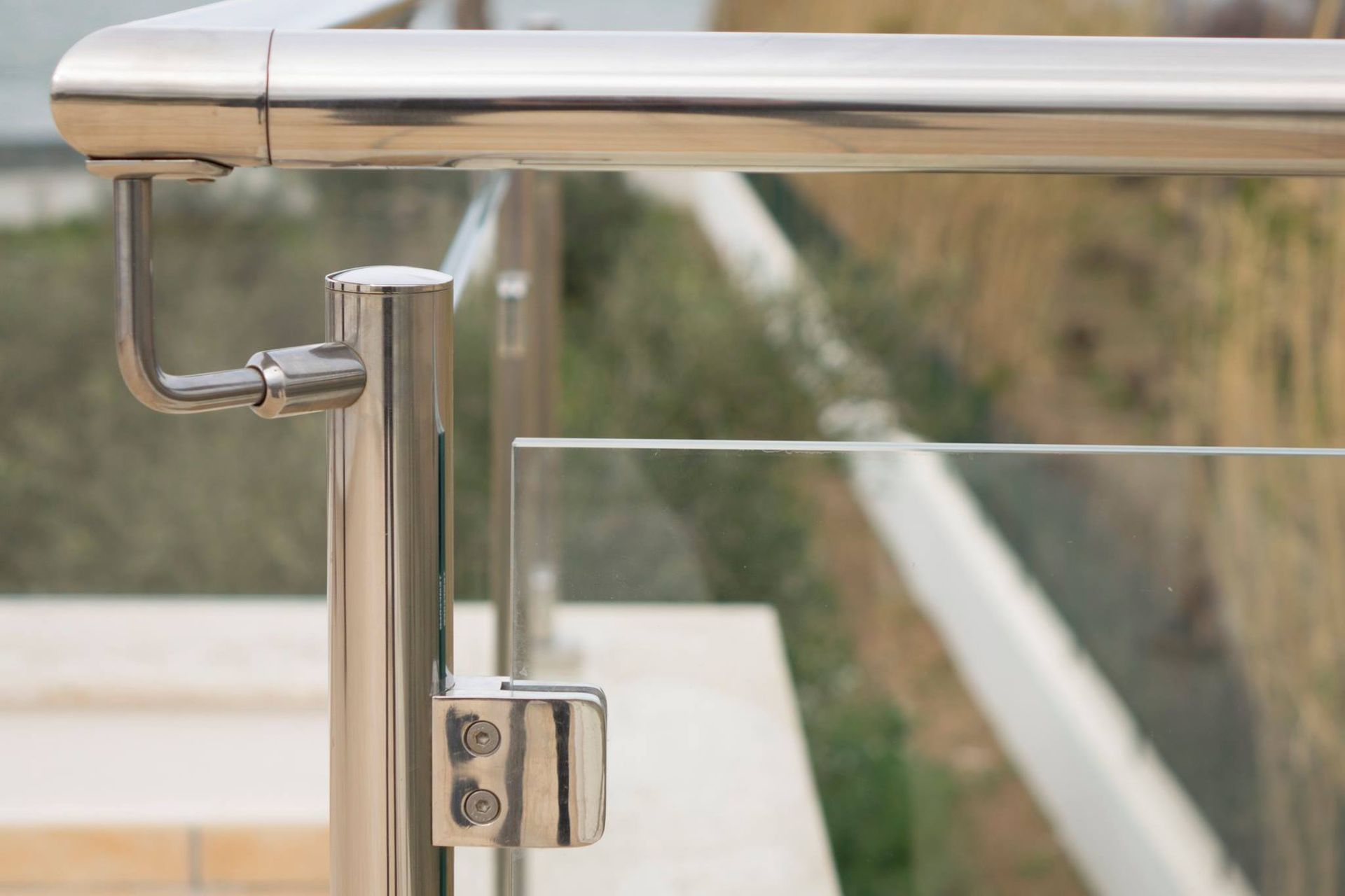 Primo piano di una ringhiera in acciaio inox con vetro.