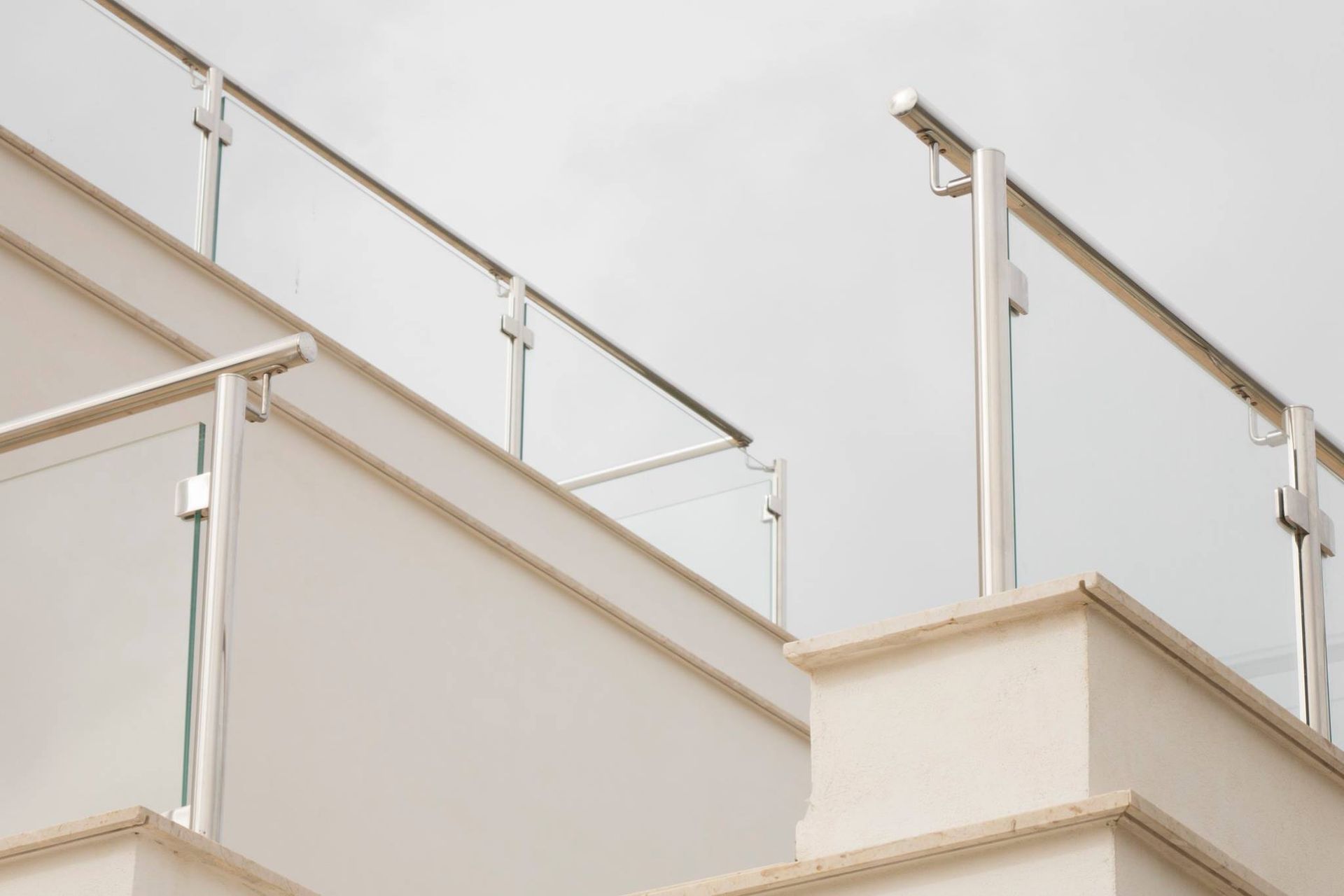 Primo piano di un balcone con ringhiera in vetro di un edificio.