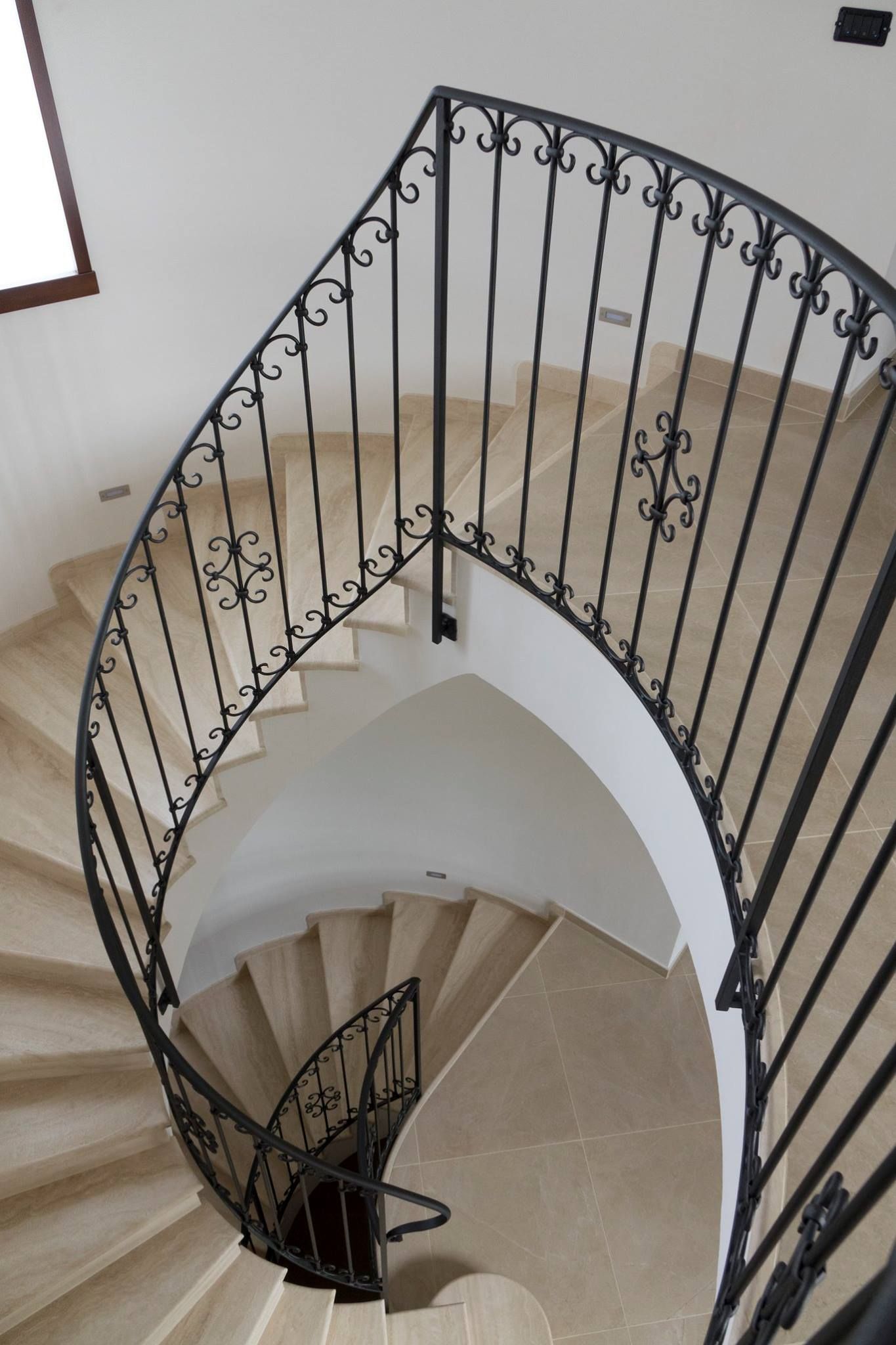 Una scala a chiocciola con ringhiera in ferro battuto