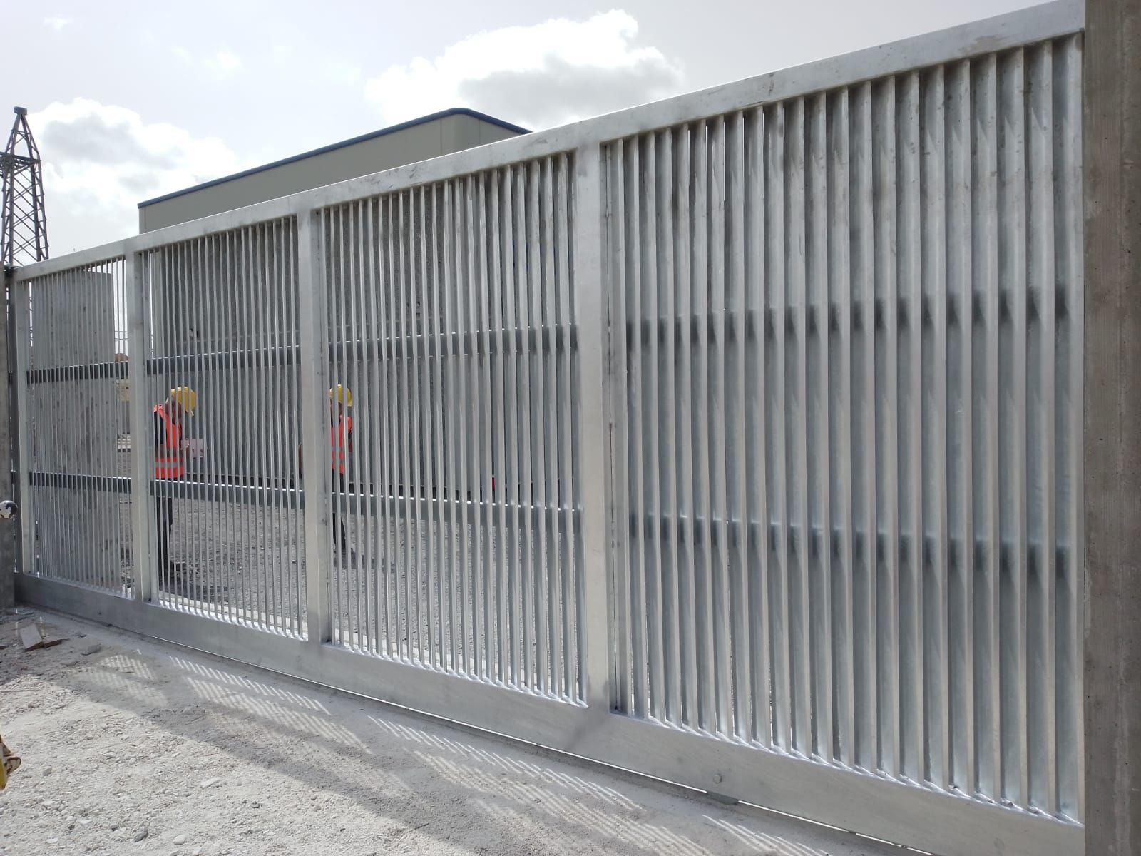 Davanti a un edificio viene costruita una recinzione con cancello scorrevole.