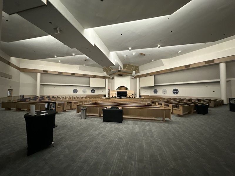An empty church with a large screen on the ceiling