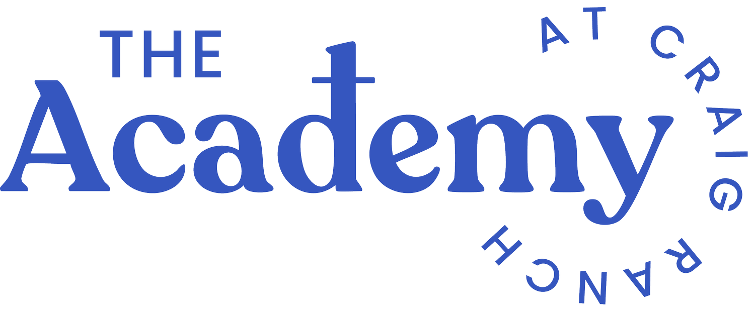 A blue logo for the academy at craig ranch