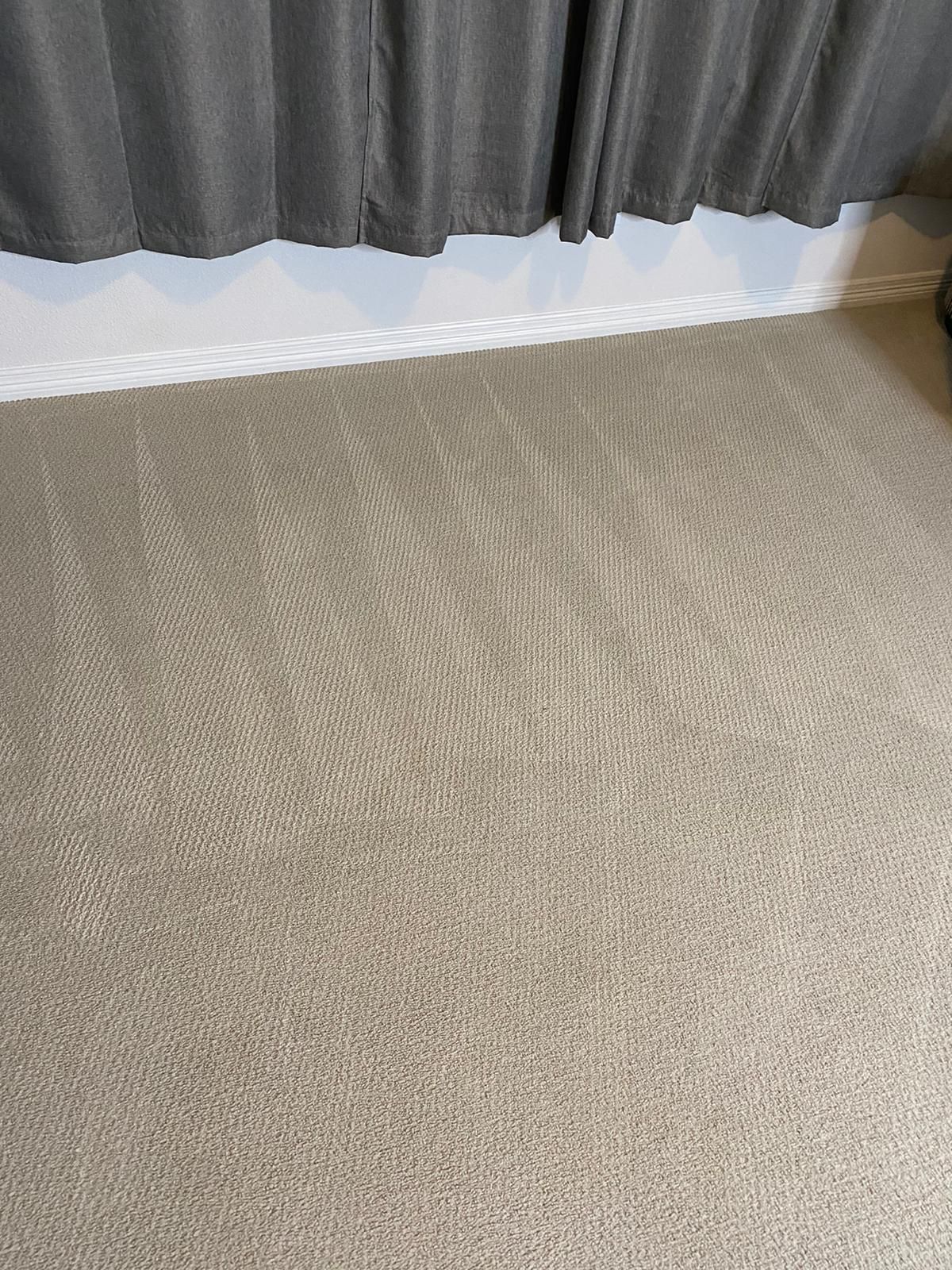 A close up of a carpet in a room with curtains.