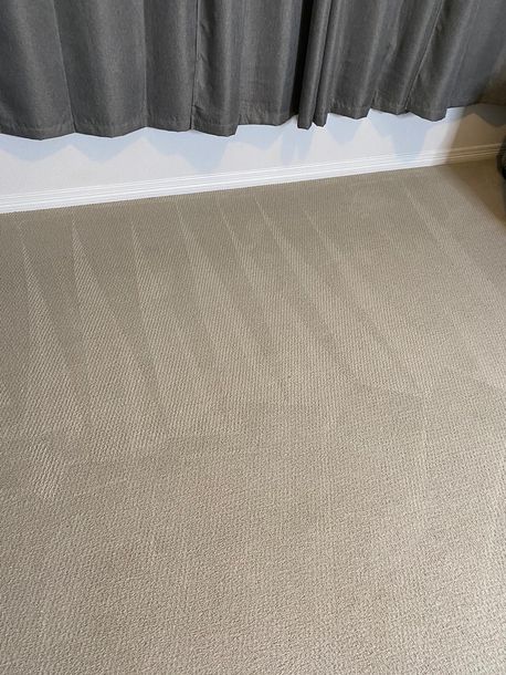 A close up of a carpet in a room with curtains.