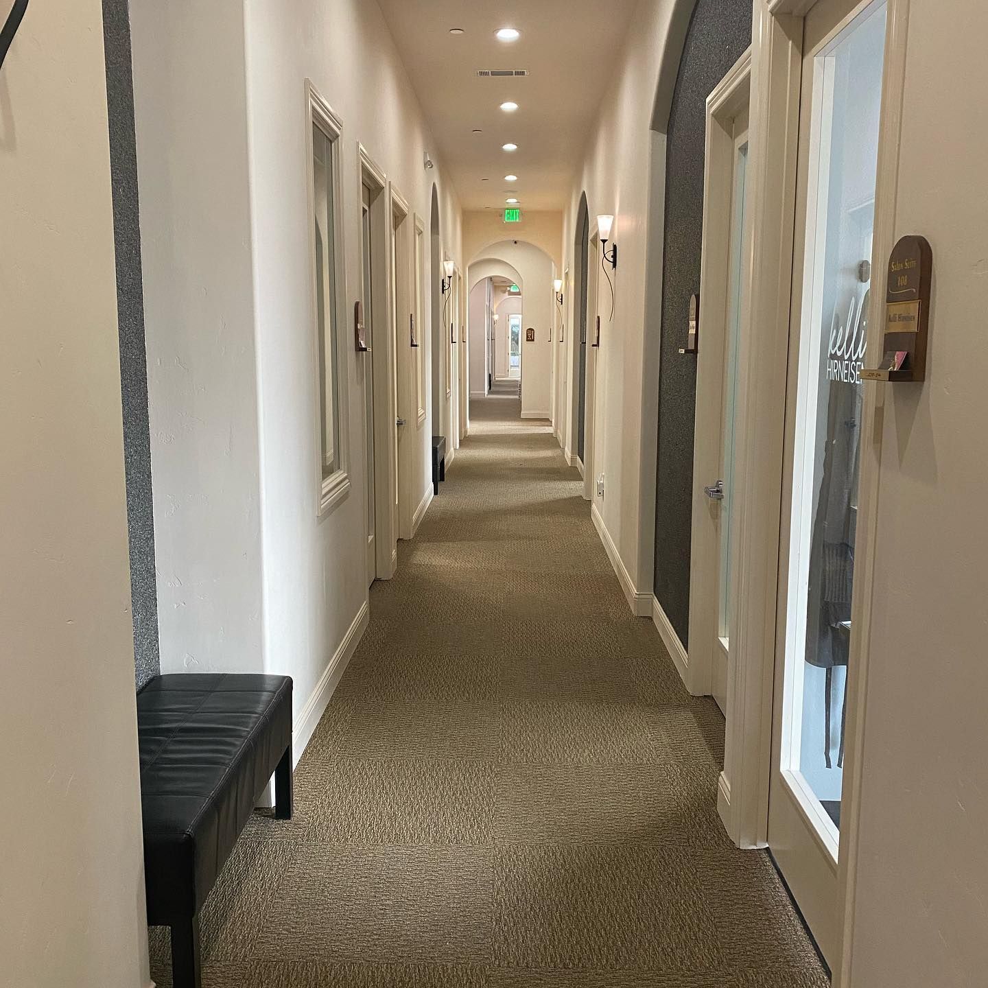 A long hallway with a bench in the middle of it