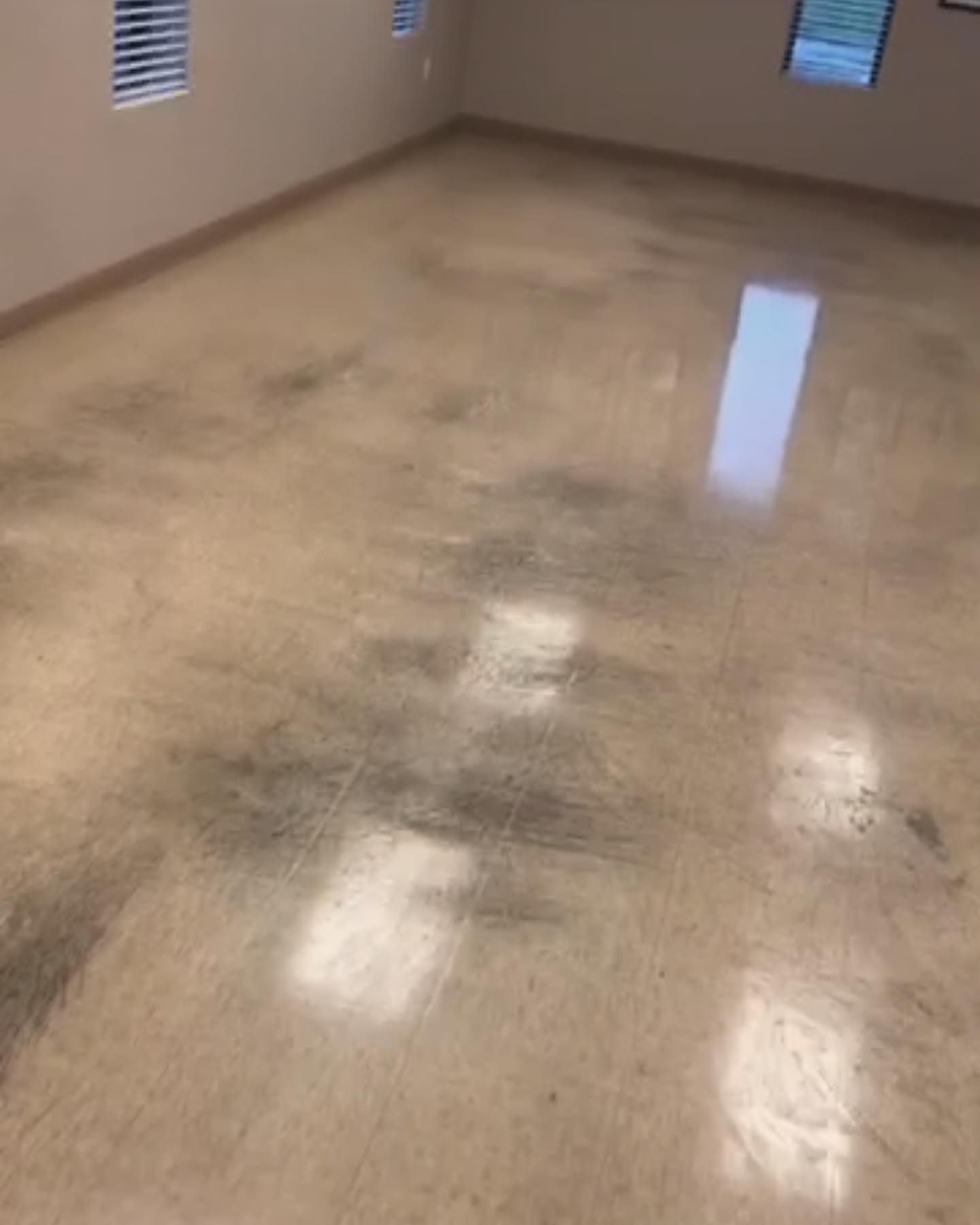 A room with a dirty floor and a window.