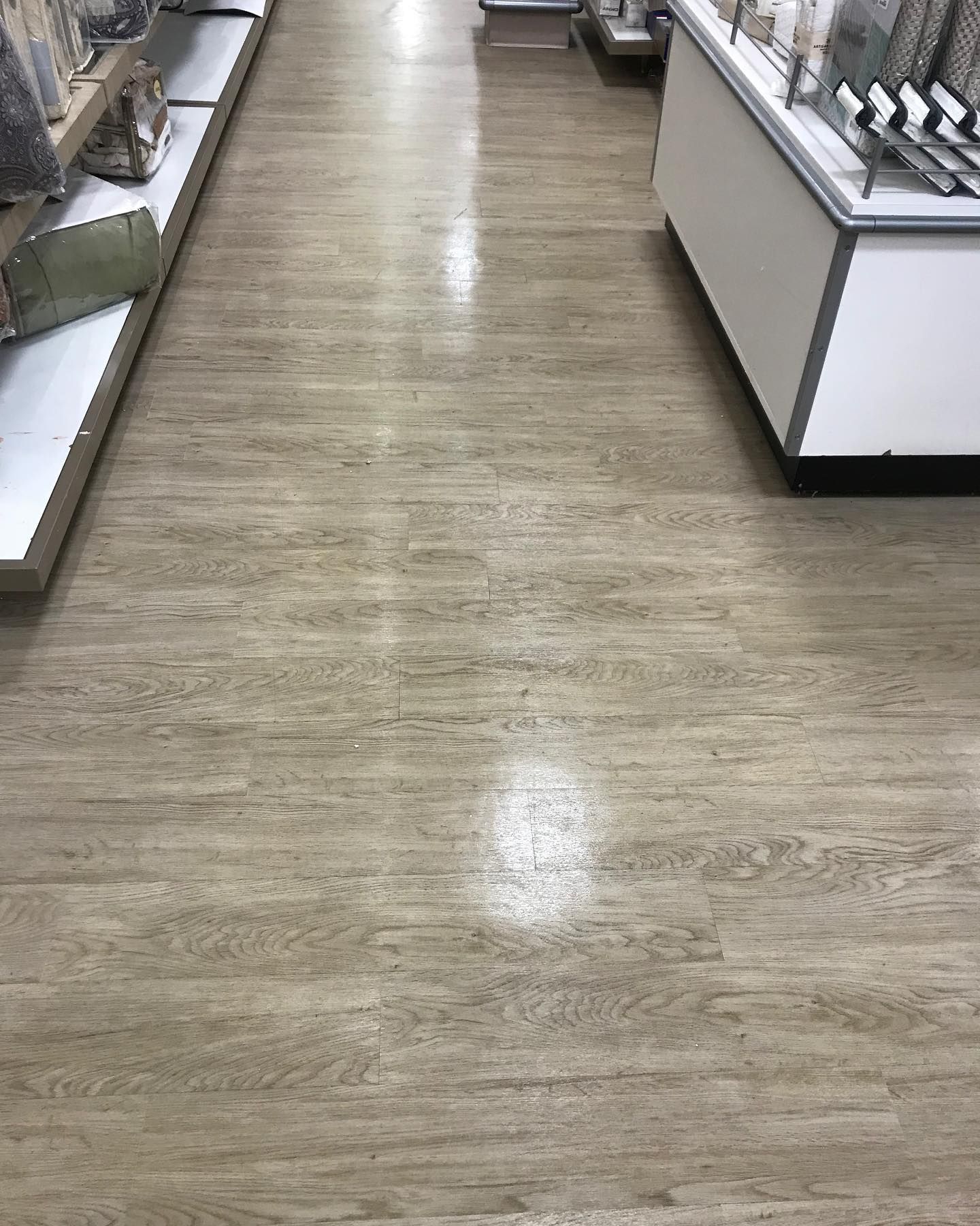 A wooden floor in a store with a lot of shelves.