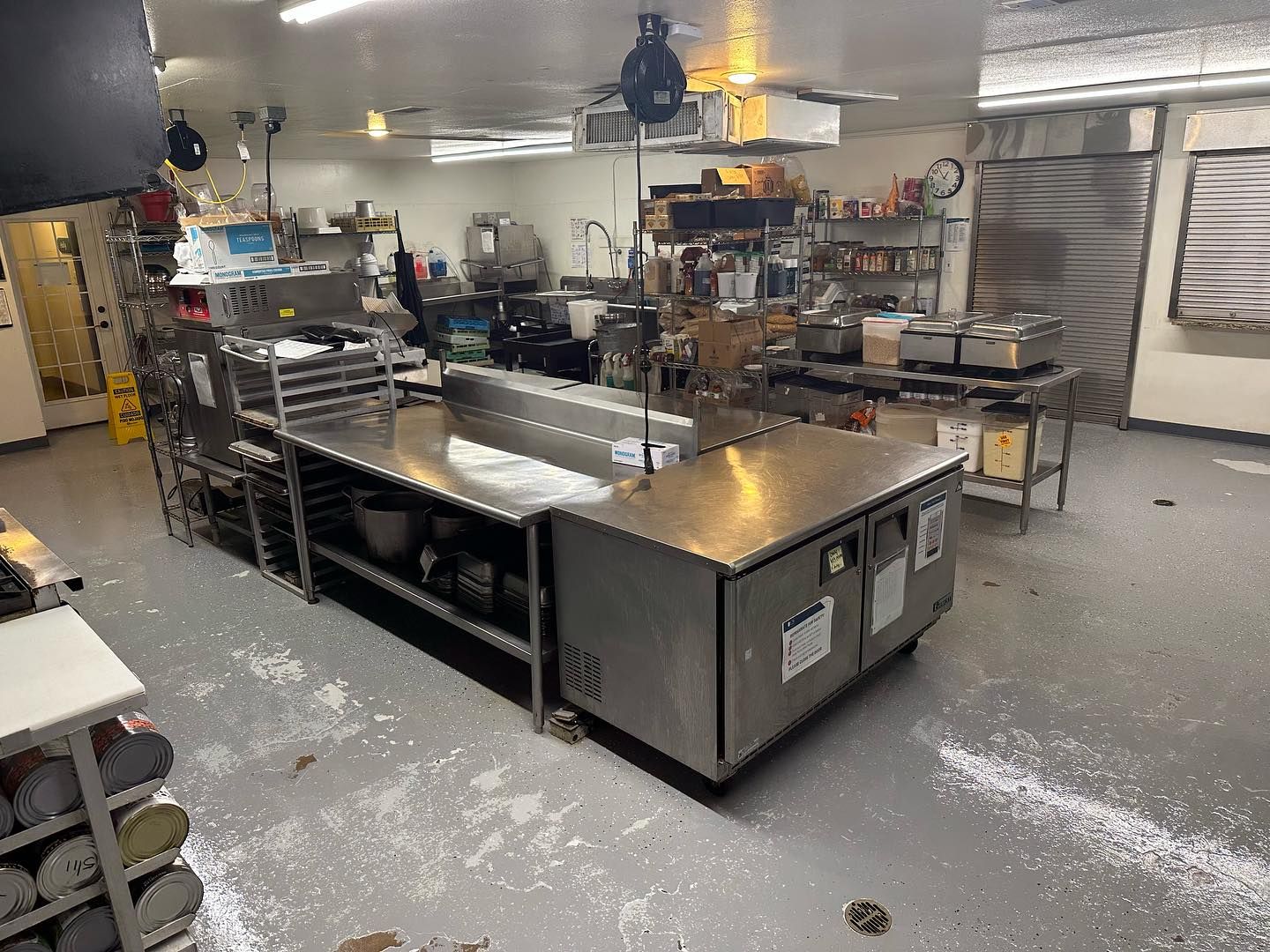 A kitchen with a lot of stainless steel appliances and counters.