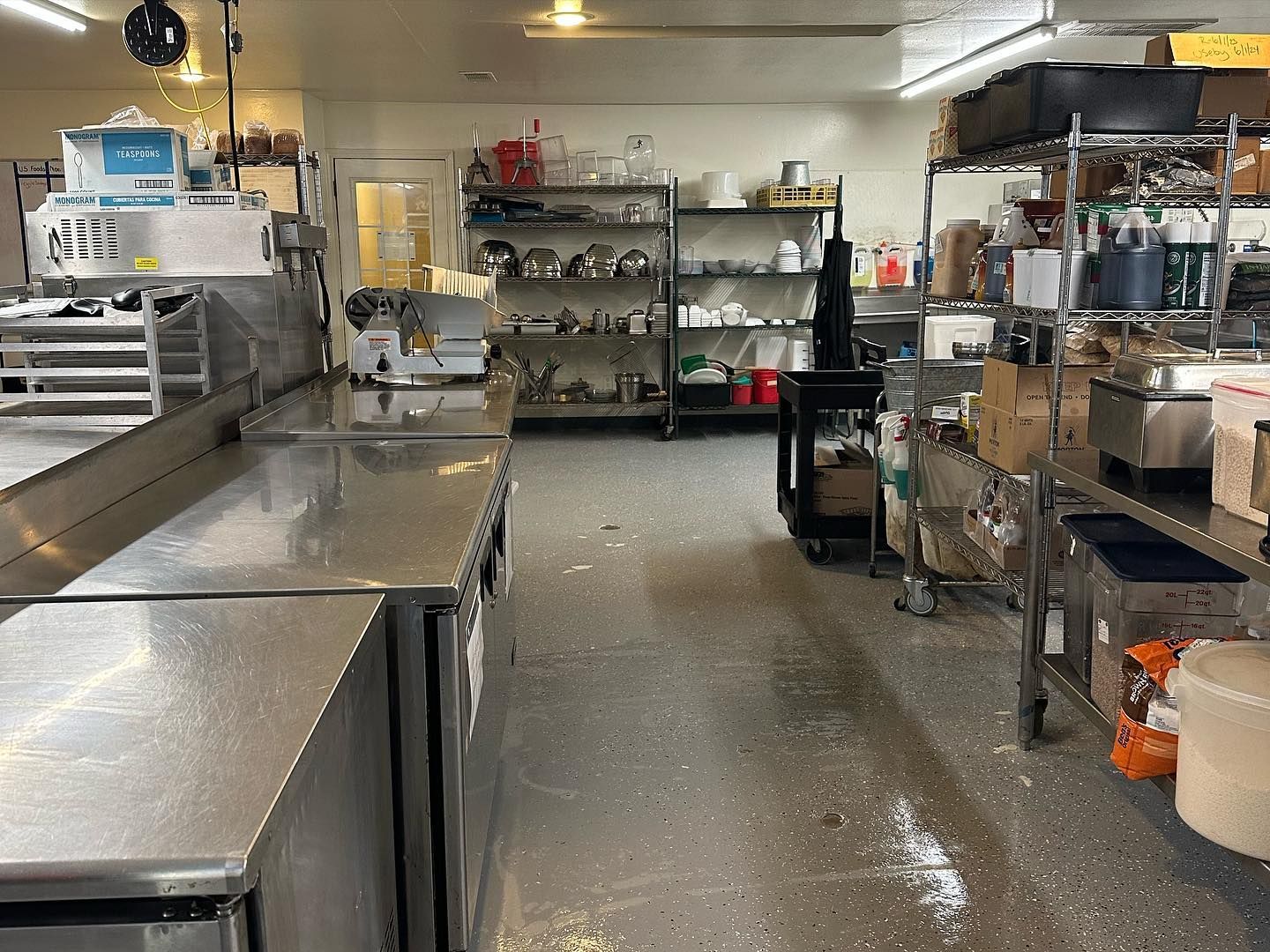 A kitchen with a lot of stainless steel appliances and shelves