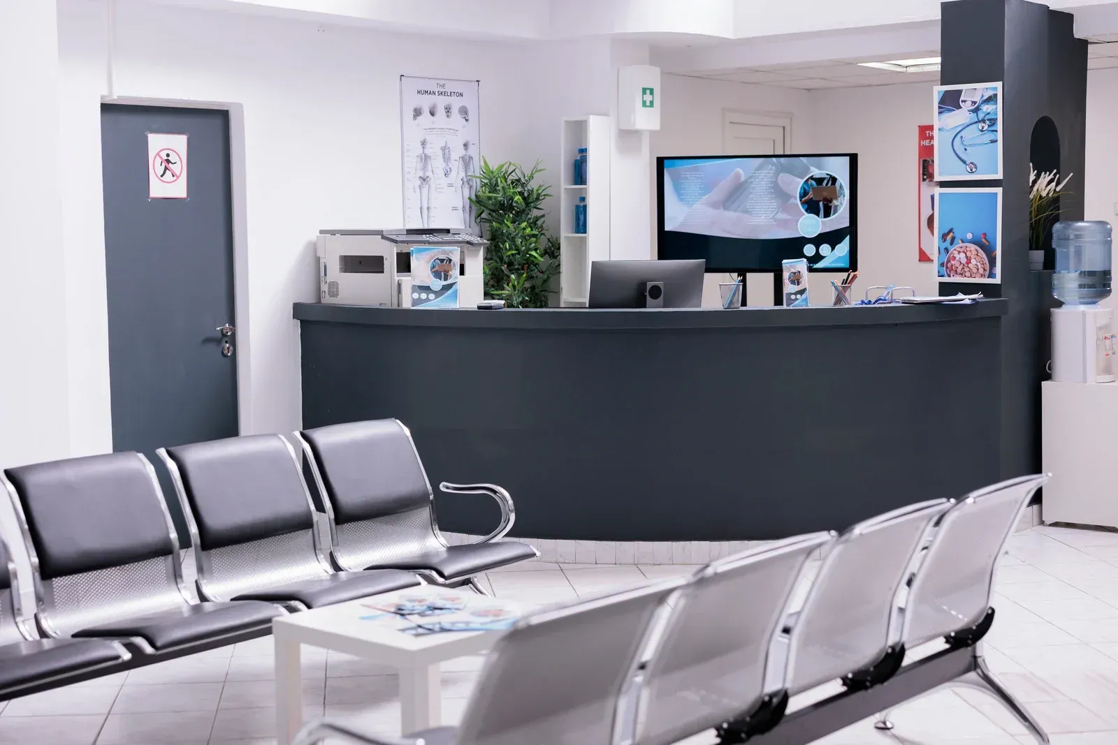 A waiting room with chairs and a counter in a hospital