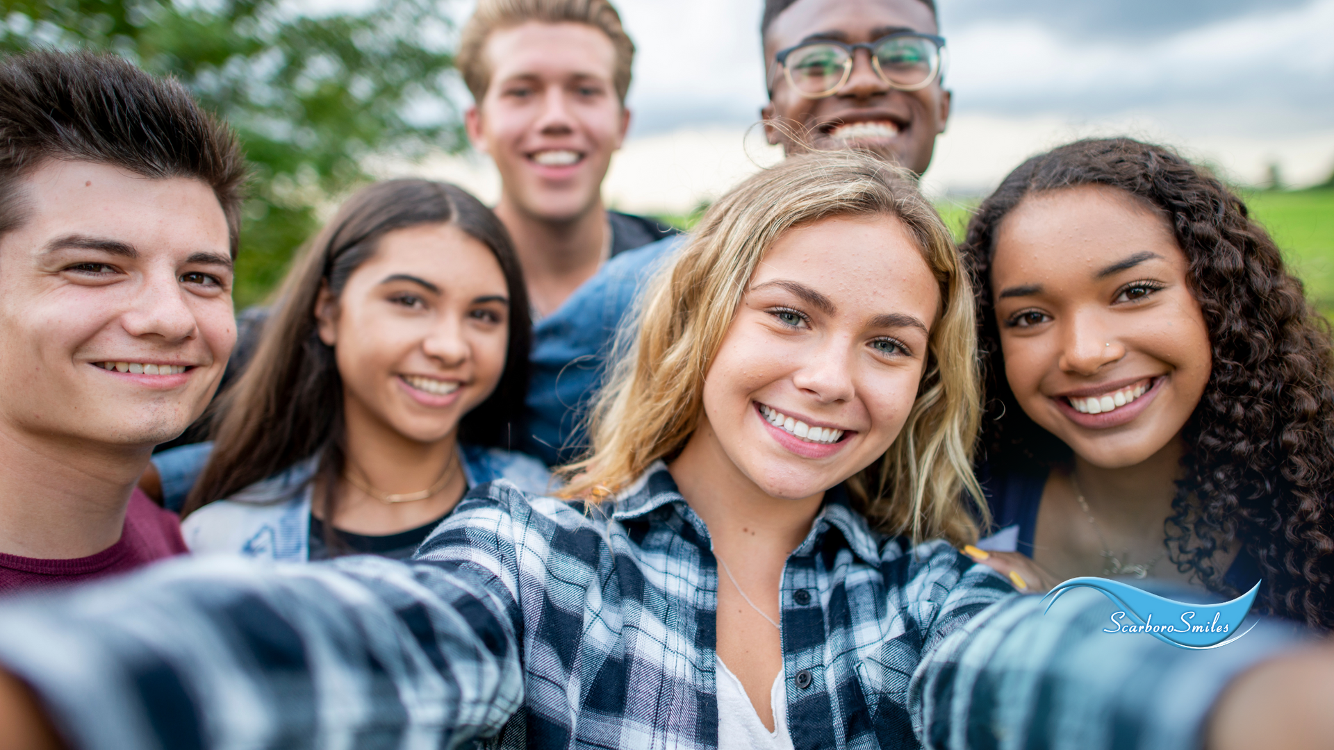 A group of young people are taking a selfie together.