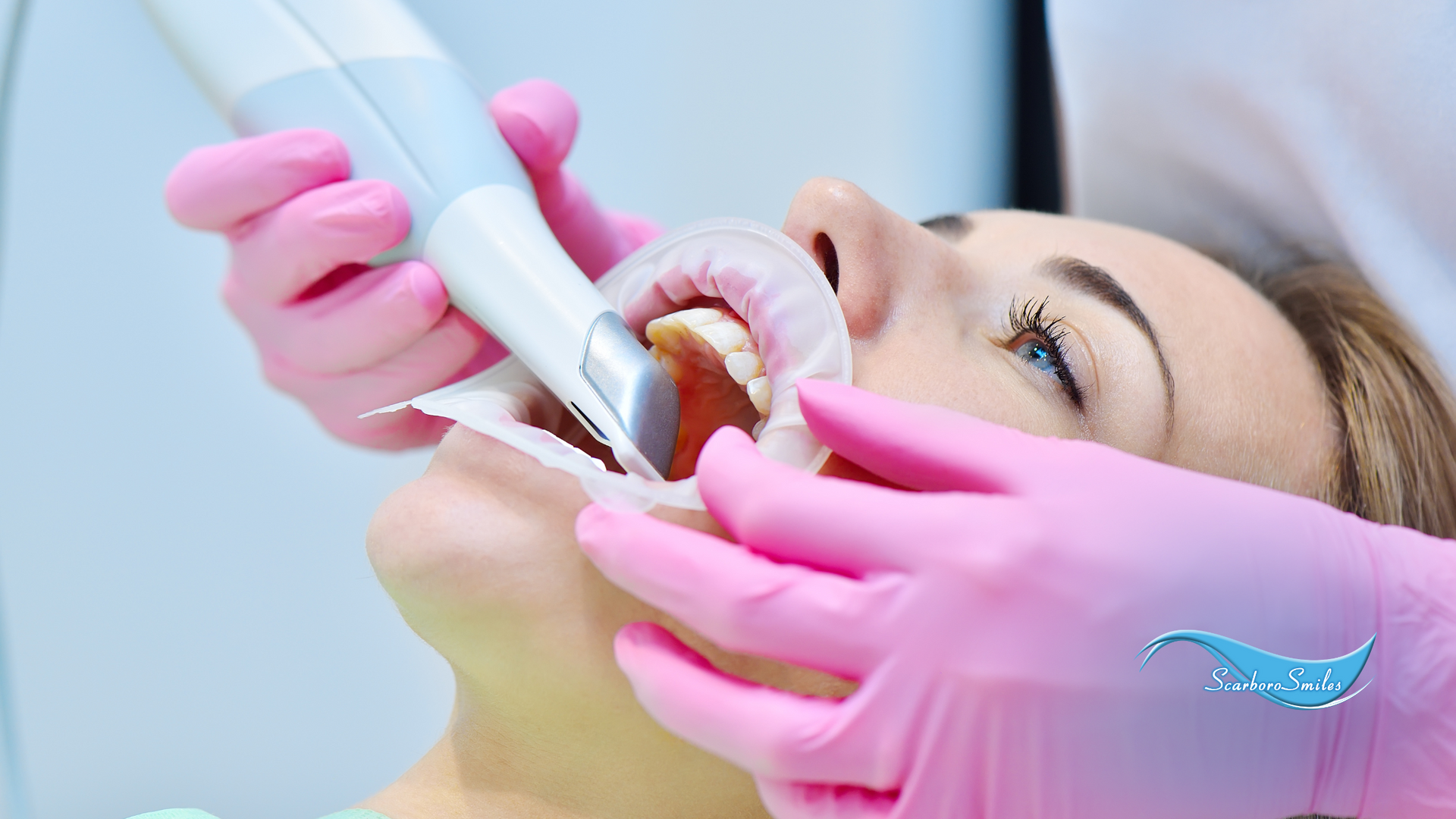 A woman is getting her teeth examined by a dentist.