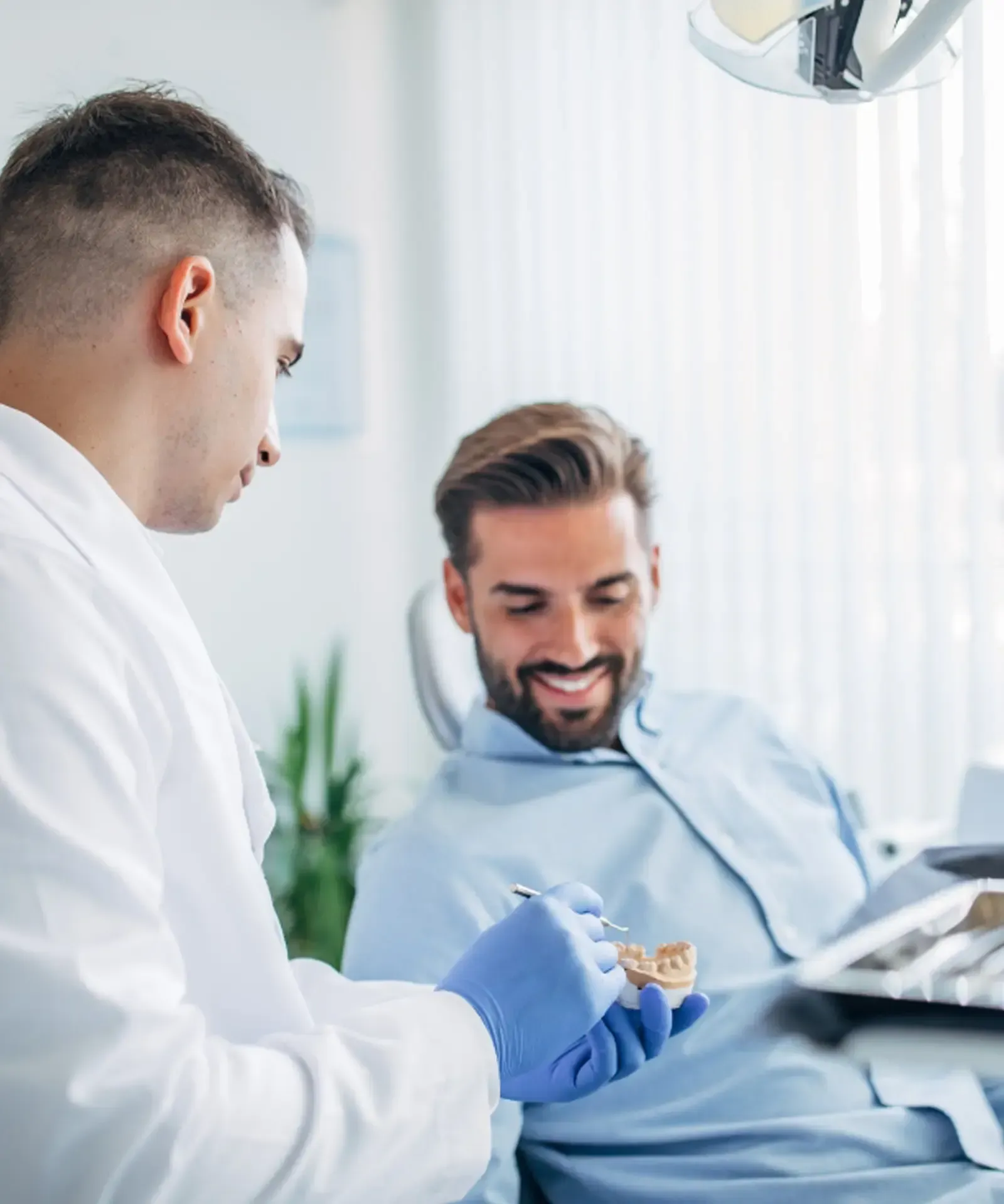 A waiting area with a TV, coffee bar, pink chairs, and a lamp. Neutral color palette, 