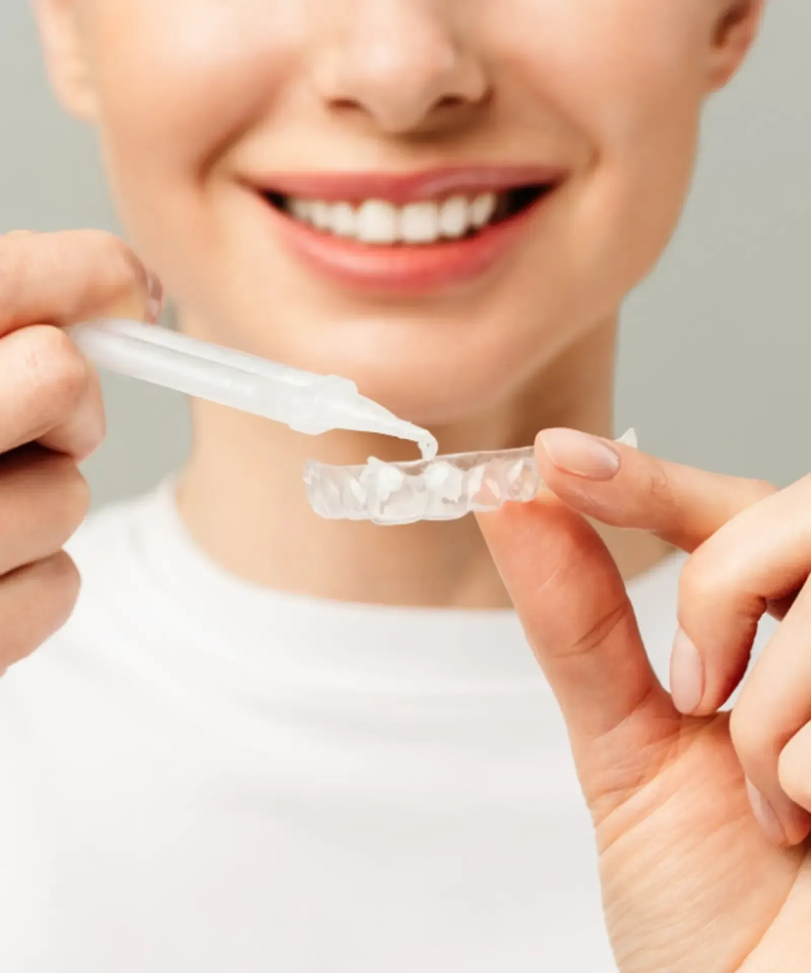 Dentist showing a model of teeth to a patient in a dental office. Both smiling.