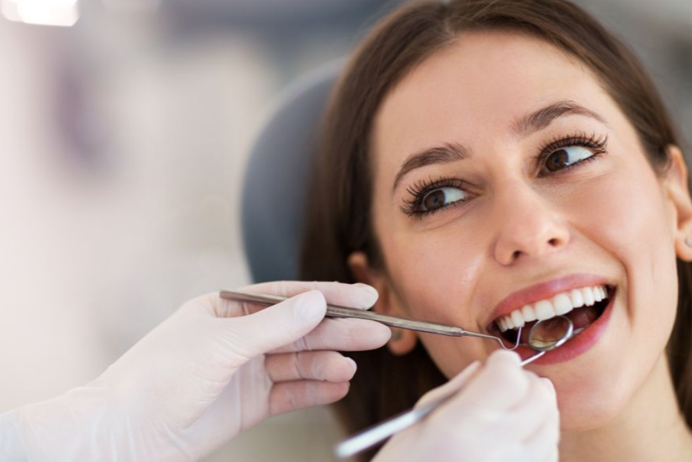 A woman is getting her teeth examined by a dentist.
