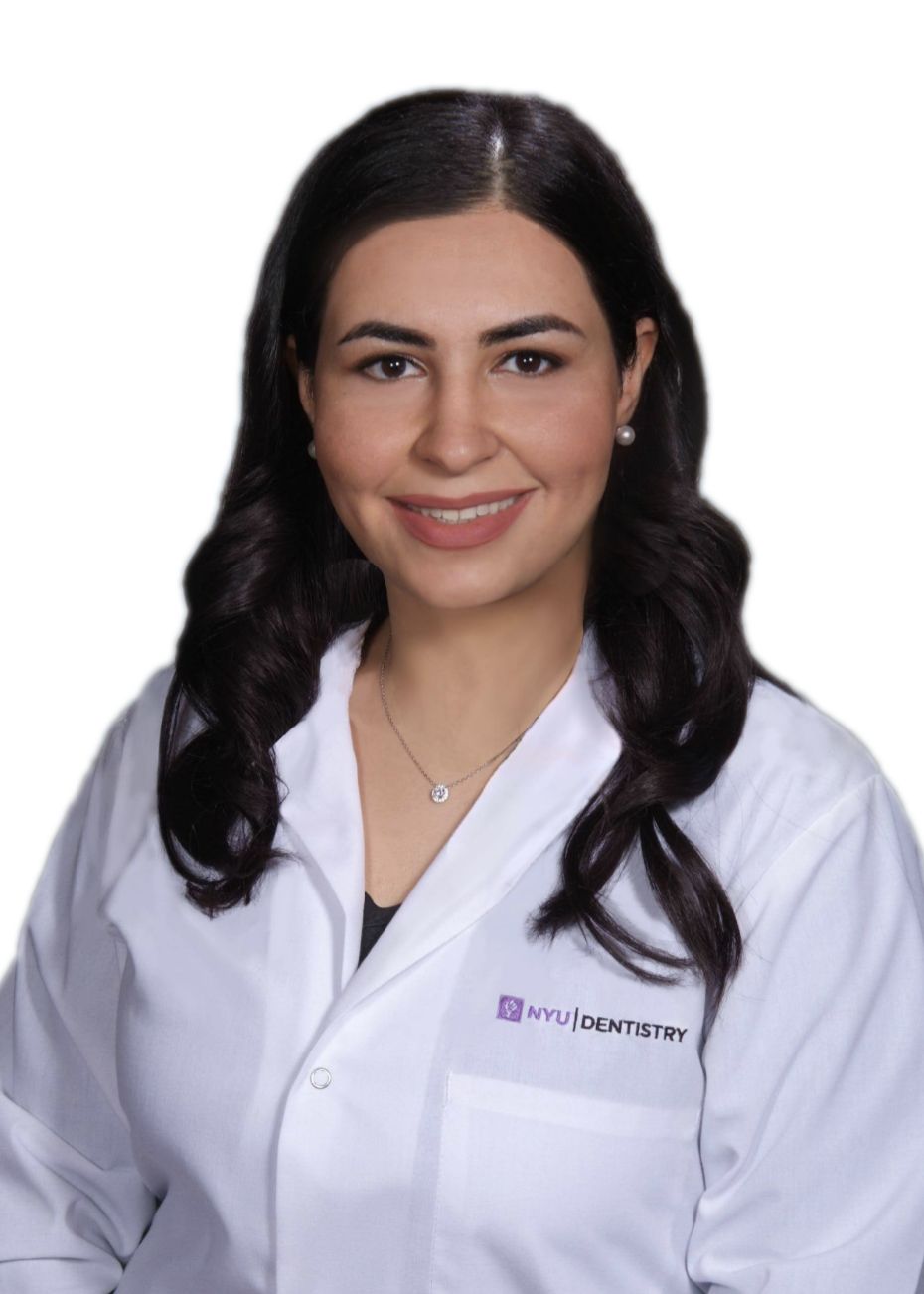 A woman in a white lab coat is smiling for the camera