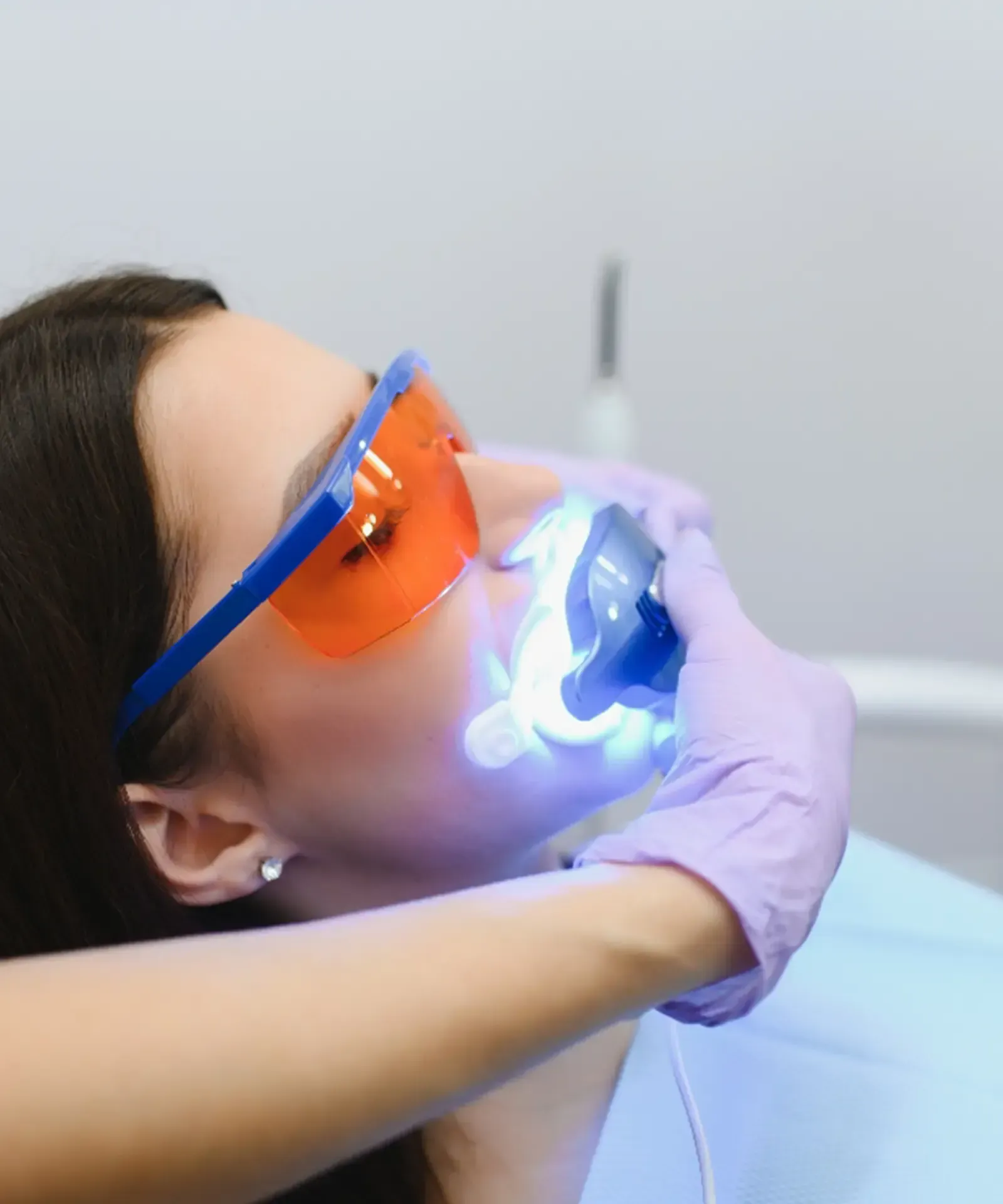 A waiting area with a TV, coffee bar, pink chairs, and a lamp. Neutral color palette,