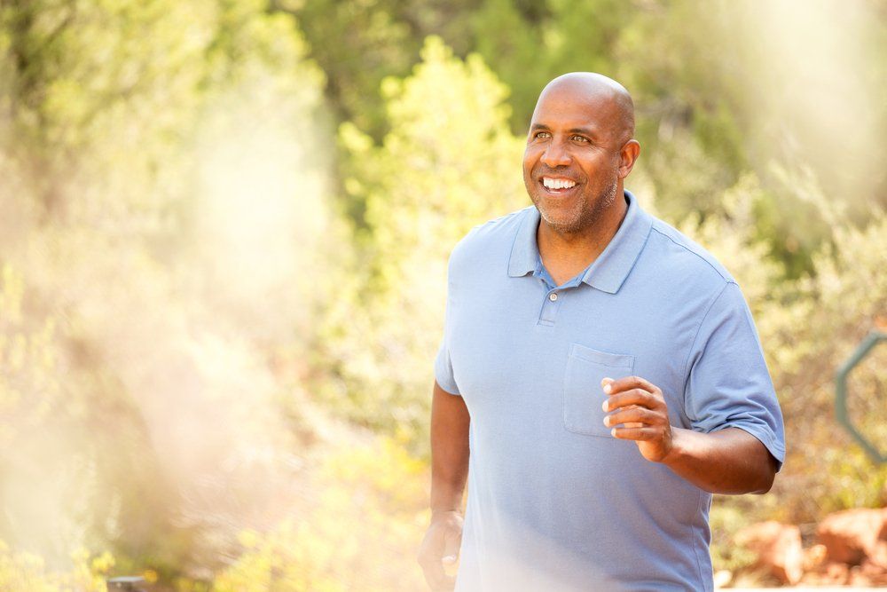 Black man outside walking and smiling | Guy on a walk enjoying nature | ScarboroSmiles | Best Dentist in Scarborough