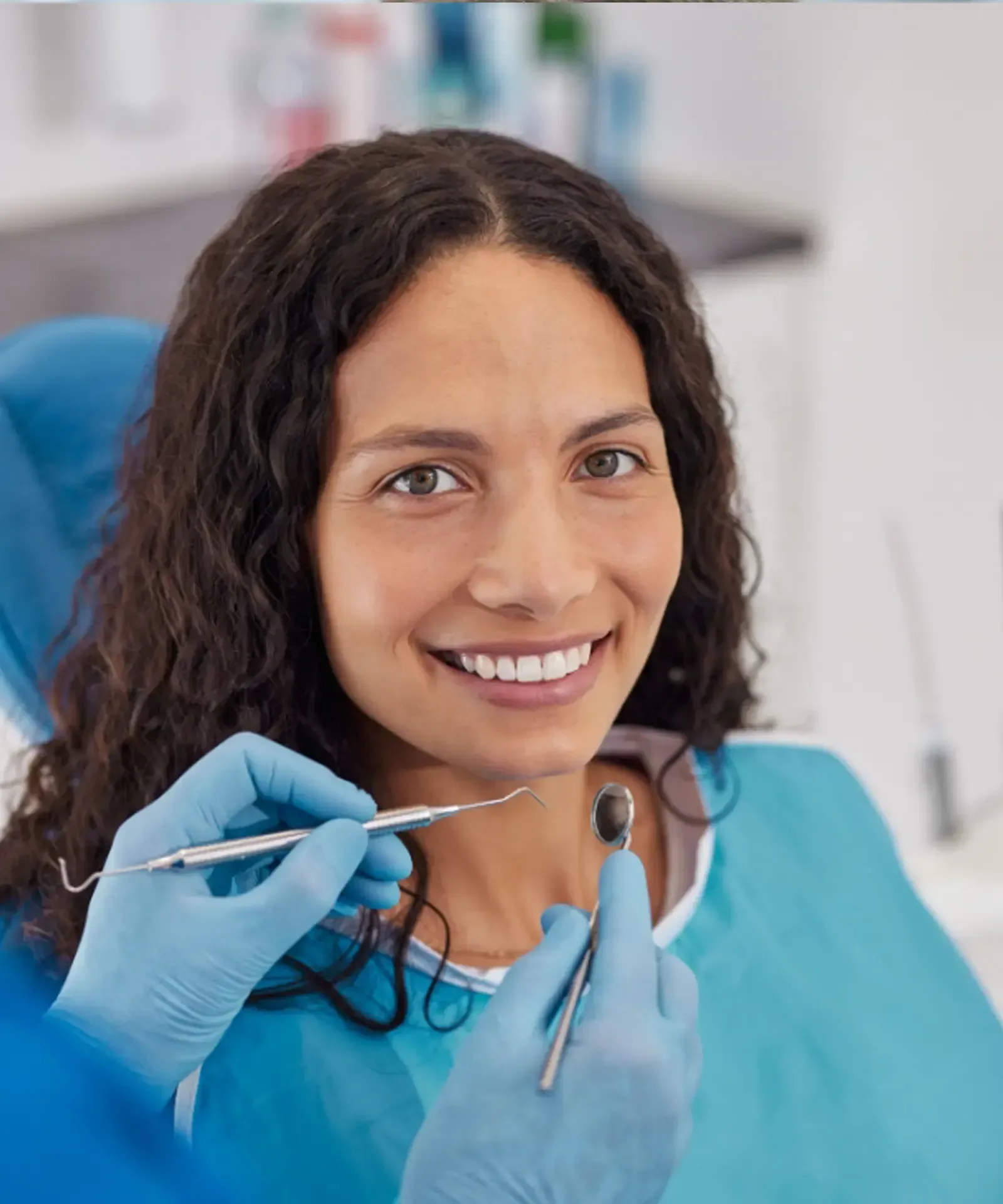 Dentist showing a model of teeth to a patient in a dental office. Both smiling.