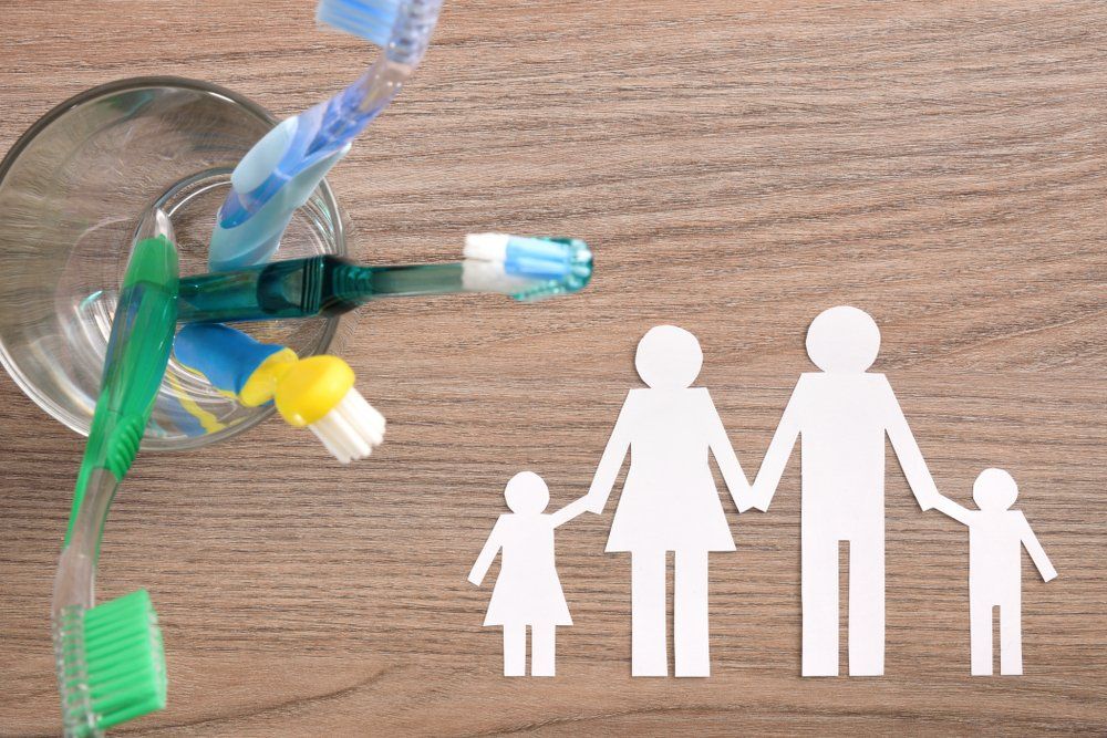 Paper Cutout Of Family Holding Hands | Toothbrushes on a Desk | Art Project About Dentistry | ScarboroSmiles | Best Dentist in Scarborough