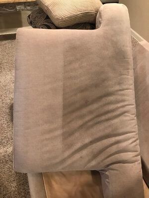 A close up of a pillow on a couch in a living room.