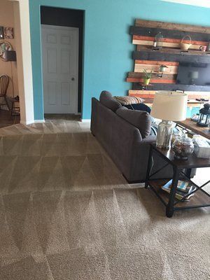 A living room with a couch , table , lamp and television.