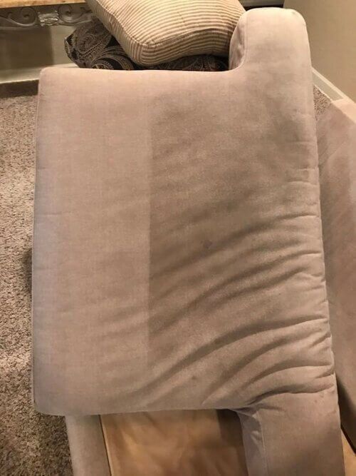 A close up of a pillow on a couch in a living room.