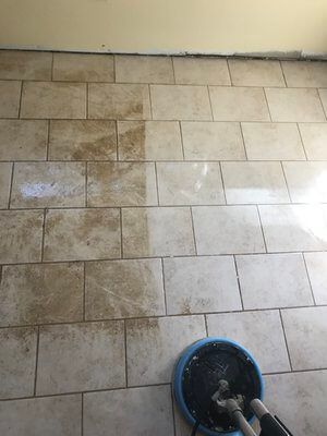 A tile floor is being cleaned with a machine.