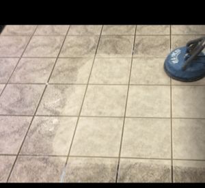A tile floor is being cleaned with a vacuum cleaner.