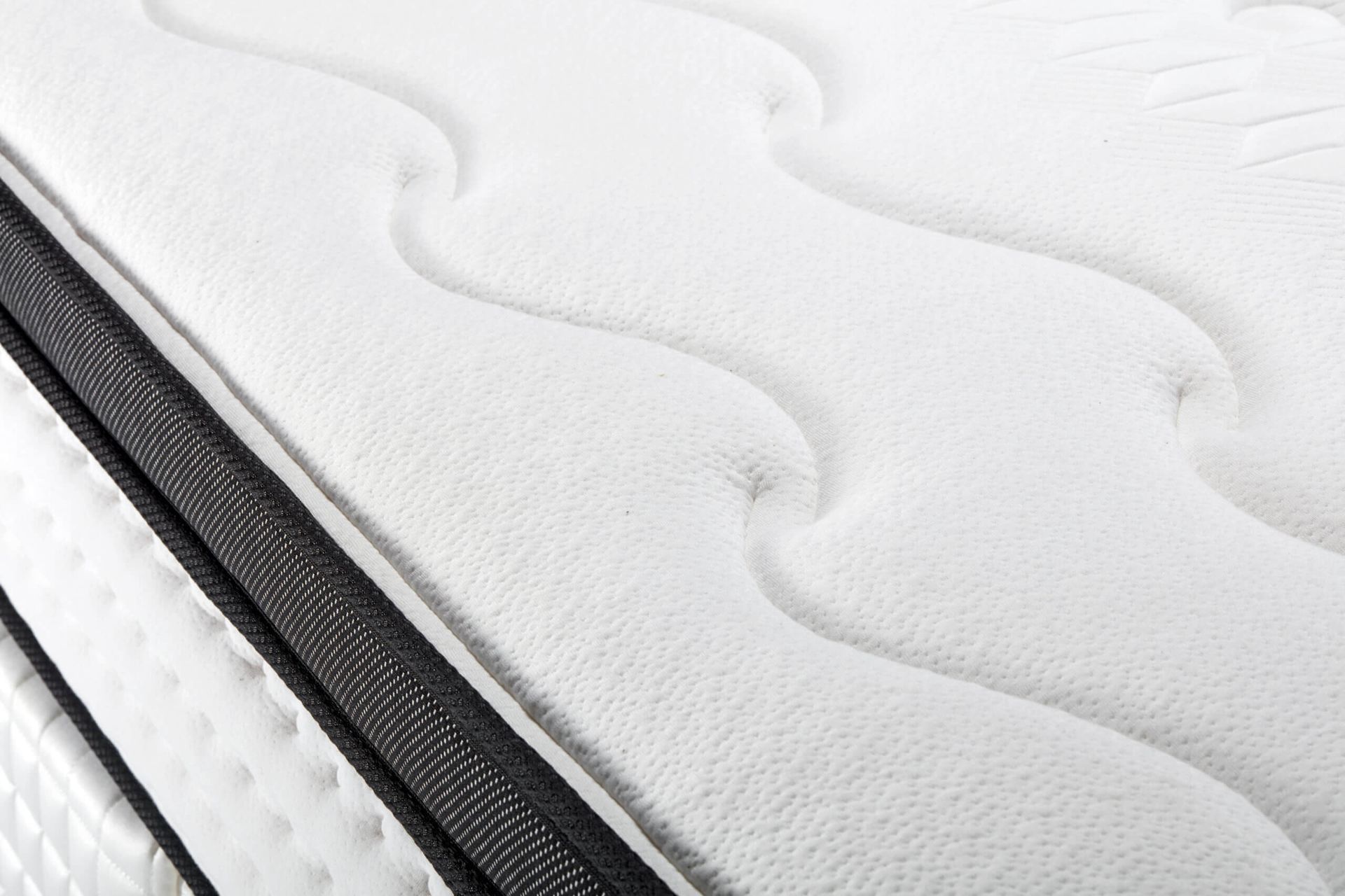 A close up of a white mattress with a black border.