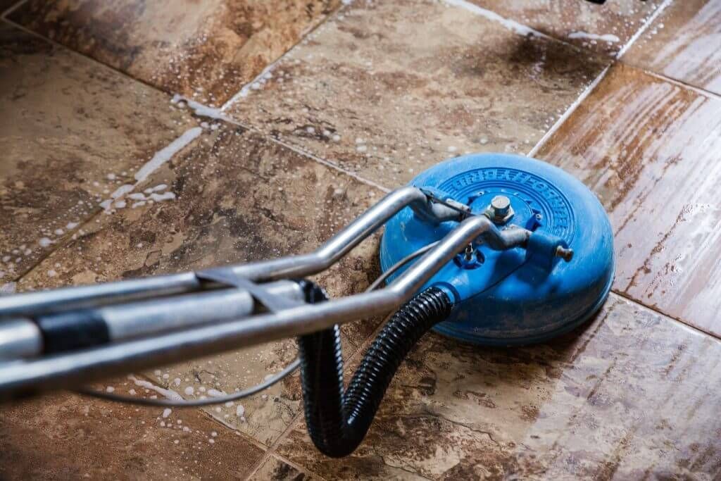 A blue vacuum cleaner is cleaning a tile floor.