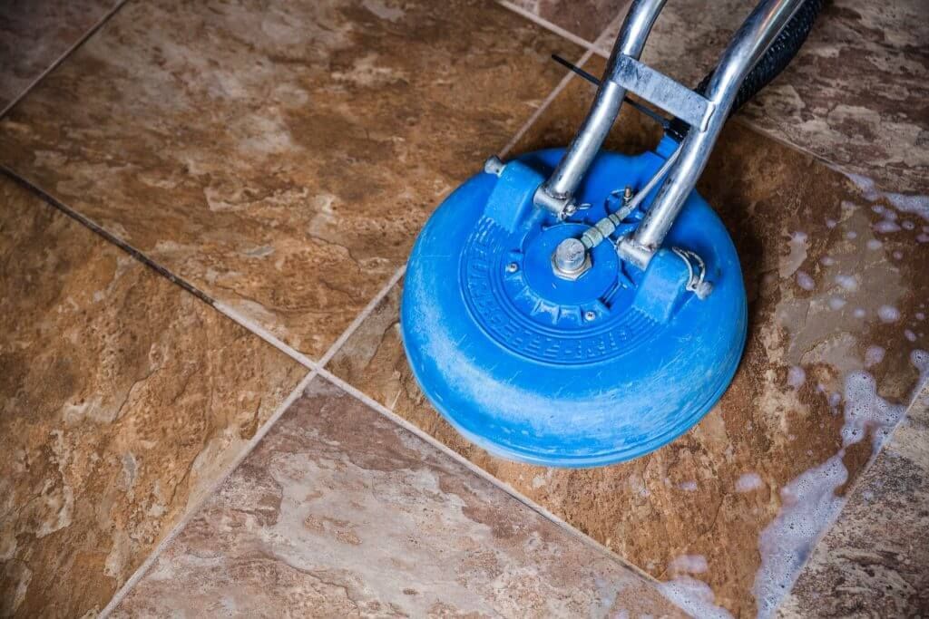 A tile floor is being cleaned with a machine.