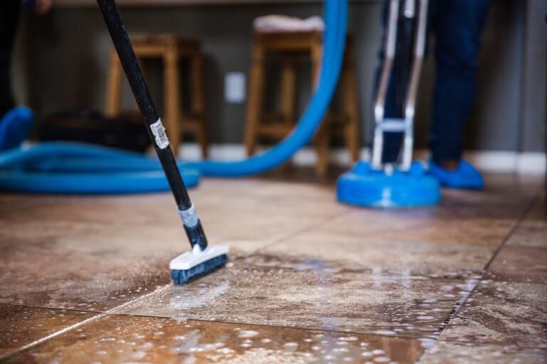 A person is cleaning a tile floor.