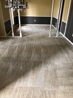 A living room with a chandelier and a carpeted floor.