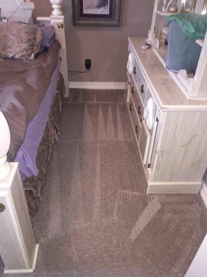 A bedroom with a bed , dresser and mirror.