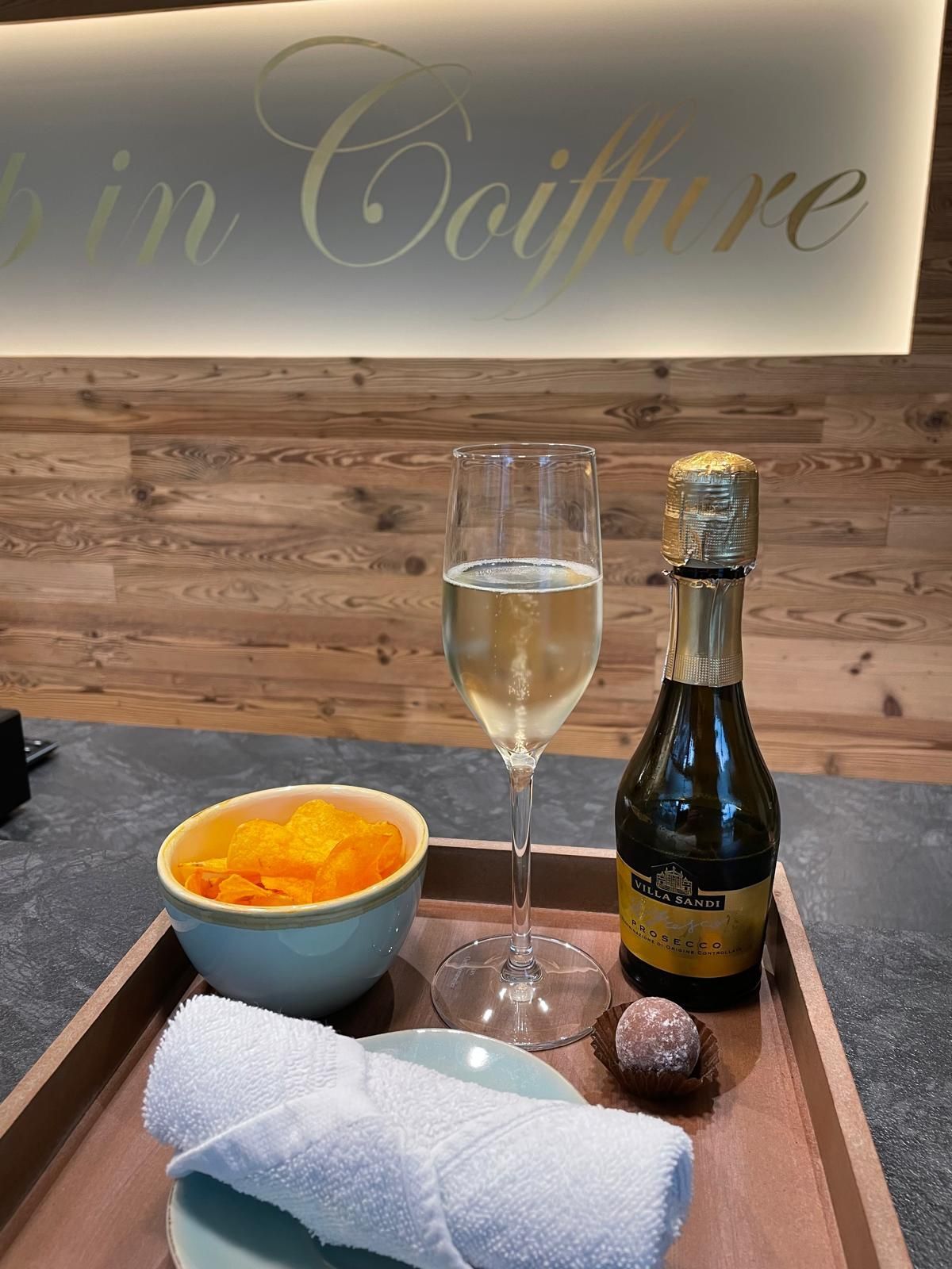 Ein Tablett mit einem Glas Wein, einer Schüssel mit Essen und einem Handtuch